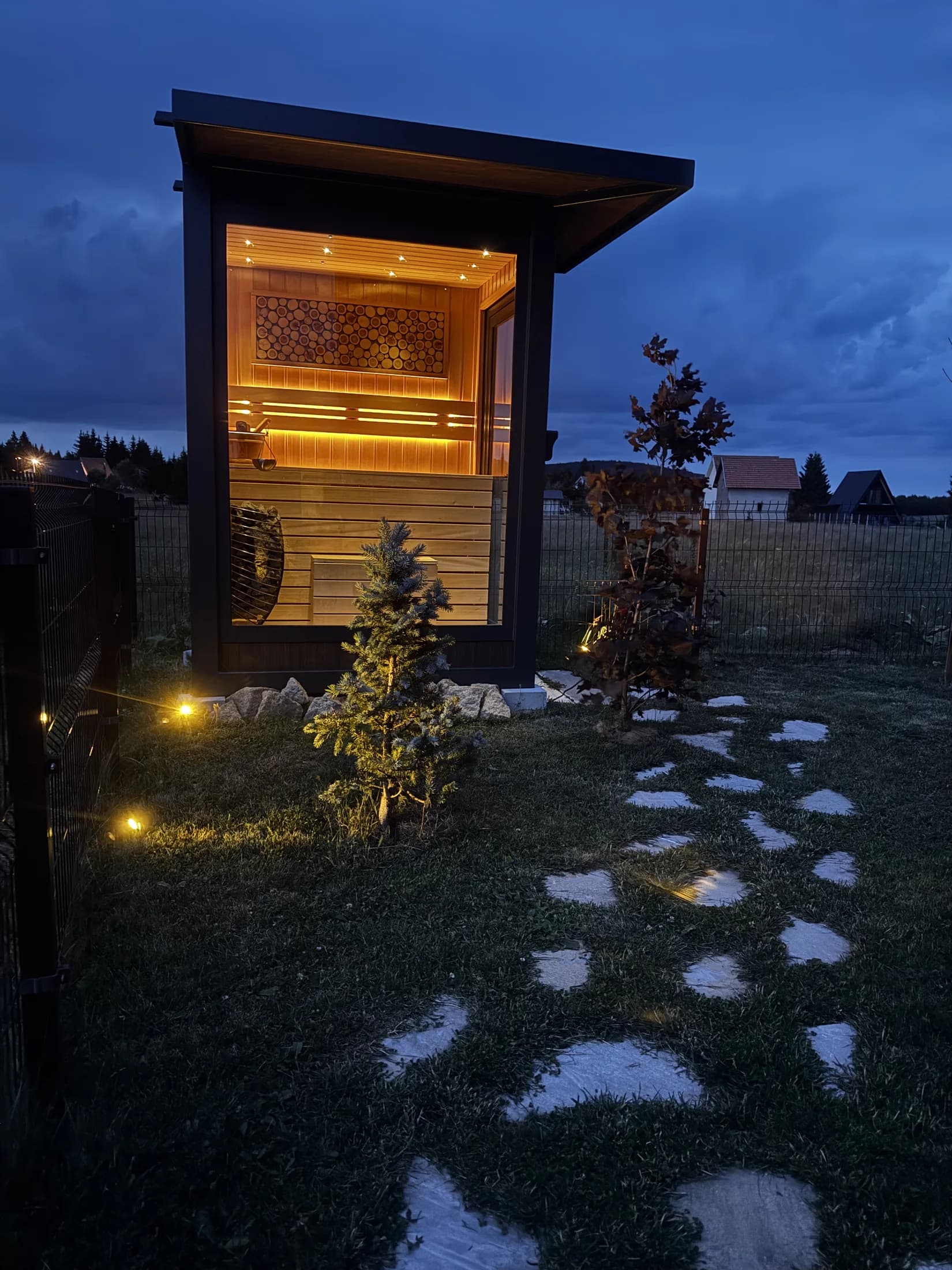 Illuminated sauna at dusk · Topli Kutak Golija